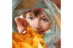 Boy reaches for potato chips.