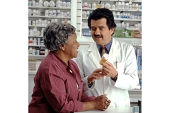 Image An older woman getting her medication from a pharmacist.
