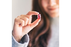 Image Woman hold a gummy in her hand.