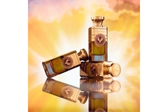 Three bottles of Electimuss London Vanilla Edesia perfume against a background of glowing clouds.