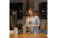 Image Woman filling bottle for baby with infant milk formula.