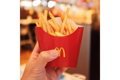 Image Hand holding up McDonald's fries packaging.