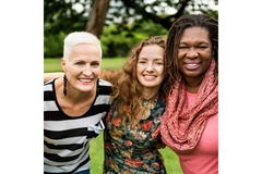 Image Three women hugging and smiling.