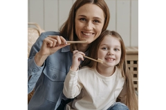 Image mother and daughter holding toothbrush to mouth