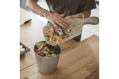Image A person is gathering chopped vegetable.