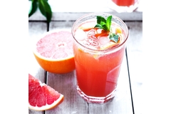 A glass of red citrus drink.