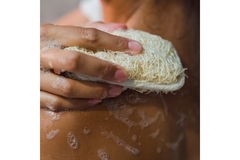 Image A hand with a sponge washing their shoulder.