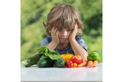 Image Child looks at vegetables.