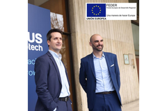Two Vytrus Biotech employees stand in front of a background with the company's name.