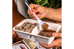 Image Closeup of Hands Holding a Dessert in a Plastic Container