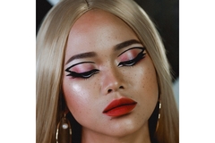 Image A woman with her eyes closed wearing black graphic eyeliner.