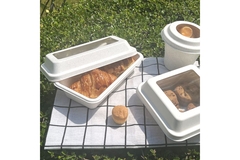 Croissants and cookies in molded fiber packaging on picnic blanket.