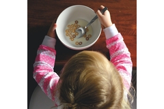 young girl having some cereal with milk