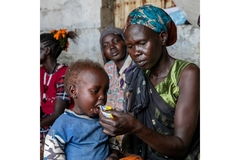 South Sudan. Woman feeding her kid.