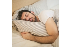 Image Man sleeping in a bed.