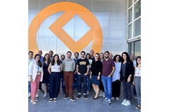 Image A group of people standing in front of a building and smiling.