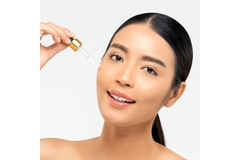 Image A woman applying face serum.