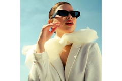 Image mean wearing blazer, tied with hair and sunglasses looks to right.