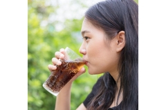 Image Woman drinking a soft drink from a glass.