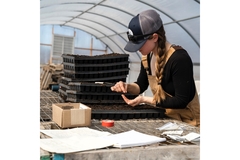 Image woman wearing overalls working with seeds