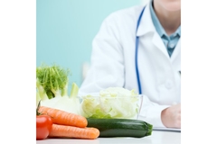 Doctor prescribing a diet, vegetables on table.
