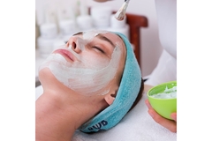 Image A woman getting a face mask put on her face.