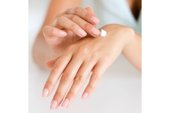 close up shot of hands with a dot of cream on top of the left hand  while the right hand is about to rub it in.