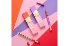 Image Refillable lip liners in front of a colorful backdrop.