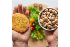 Image A person is holding a plant-based burger and beans.
