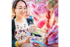 Image Girl choosing lollipops in a candy store.