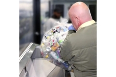 Image person dumping beverage containers into a collection machine for deposit return