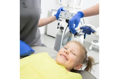 Image Girl in a dentist chair, about to undergo dental surgery.