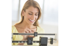 Woman measuring her weight.