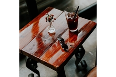 Image A glass of soda on a table next to a pair of sunglasses.