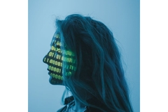 Image Dark side profile of a woman with coding projected onto her face.
