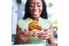 Image Woman eating chicken burger.