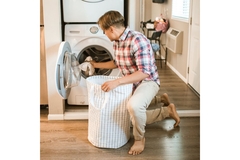 Image A Man putting Clothes on the Laundry Machine