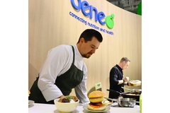 A chef displaying alternative meat dishes at a trade show.