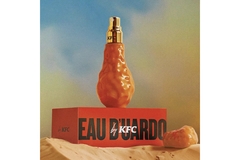 Image A bottle of Eau D'uardo by KFC sticking out of the sand.