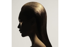 Image A woman with her skin and hair painted gold.