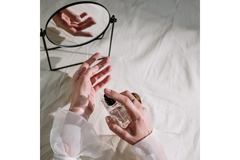 Image Hands spraying perfume on a wrist.