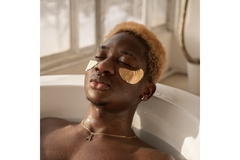 Image A man sitting in a bath with eye masks on.