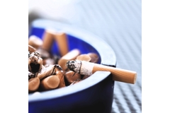 Image burning cigarette resting on an ash tray