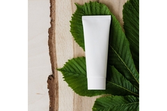 Image A labelless skincare product on top of a leaf.