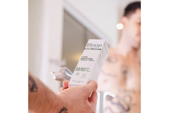 Image A man holding a cream in the mirror.
