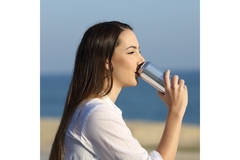 Image Woman drinks out of can.