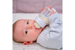 Baby drinking out of a bottle.