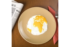 A sunny-side-up egg with its yellow yolk in the shape of a world map.