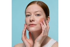 Image A woman touching her cheeks.