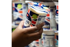 Image Person holding yogurt cup.